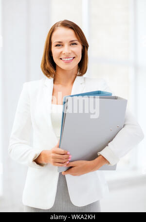 Geschäftsfrau mit Ordnern im Büro Stockfoto