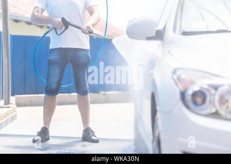 Man waschen Auto Rad mit hohem Druck maschine für Auto waschen Stockfoto