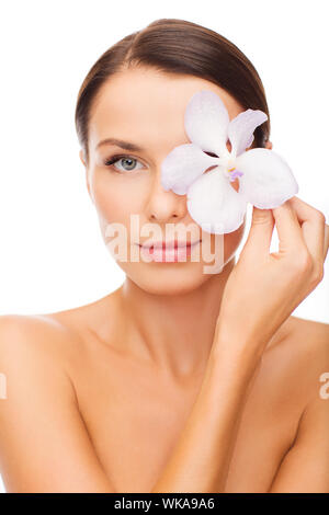 Gesundheit und Schönheit-Konzept - entspannte Frau mit orСЃhid Blume über Auge Stockfoto