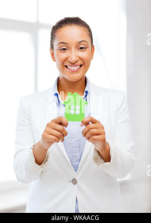 Büro, Geschäft, Eco, energiesparend und Immobilien Konzept - afrikanische Frau mit Grünbuch Haus Stockfoto