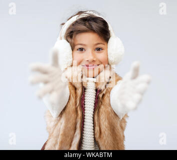 Winter, Menschen, Glück Konzept - glückliches kleines Mädchen in Winterkleidung Stockfoto