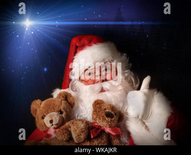 Santa lächelnd hält Spielzeug Teddybären in seine Arme Aginst ein Nachthimmel Stockfoto