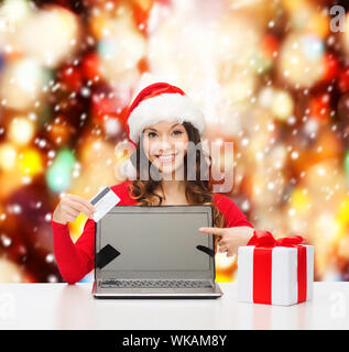 Frau mit Geschenk, Laptop-Computer und Kreditkarte Stockfoto