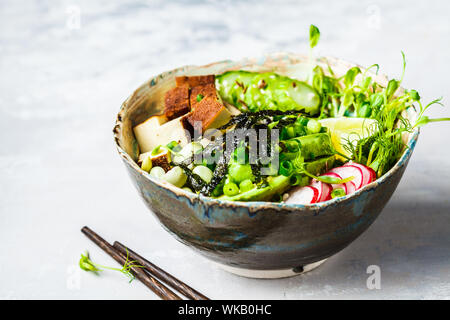 Poke Schüssel mit Avocado, schwarzer Reis, geräucherter Tofu, Gemüse, Sprossen, weisser Hintergrund. Stockfoto