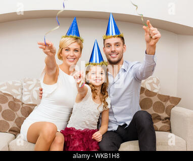 lächelnde Familie in blaue Mützen mit Kuchen Stockfoto