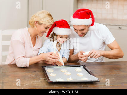 Happy Family im Santa Helfer Hüte machen cookies Stockfoto