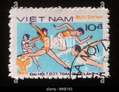 Stempel gedruckt in Vietnam zeigt, Gymnastik, Laufen und Schwimmen, 1. Nationale Sportfest, circa 1985. Stockfoto