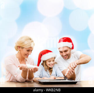 Happy Family im Santa Helfer Hüte machen cookies Stockfoto