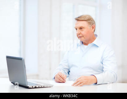 Wirtschaft, Steuer, Büro, Schule und Bildung-Konzept - Greis Ausfüllen eines Formulars im in- Stockfoto