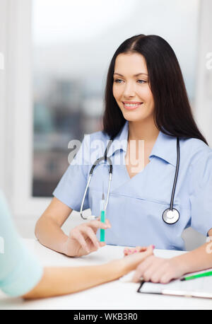 lächelnd Ärztin oder Krankenschwester mit Spritze Stockfoto