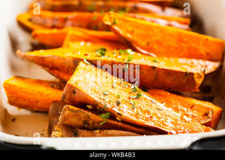 Gebackene süsse Kartoffel Scheiben mit Gewürzen in der auflaufform. Gesunde vegane Ernährung Konzept. Stockfoto