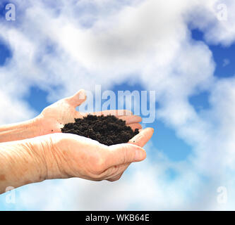 Boden in Händen, Himmel mit Wolken Stockfoto