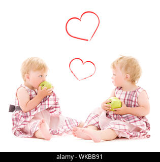 Kinder und Glück Konzept - zwei adorable Zwillinge mit Äpfeln über Weiß Stockfoto