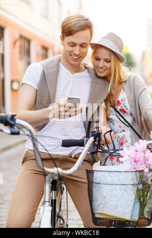 paar mit Smartphone und Fahrräder in der Stadt Stockfoto