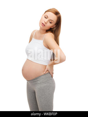 Schwangerschaft, Mutterschaft und Glück Konzept - müde werdenden Mutter unterstützt ihren Rücken Stockfoto