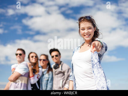 Sommerferien und Teenage Konzept-Jugendmädchen in Sonnenbrille heraus hängen mit Freunden draußen und zeigen Daumen hoch Stockfoto