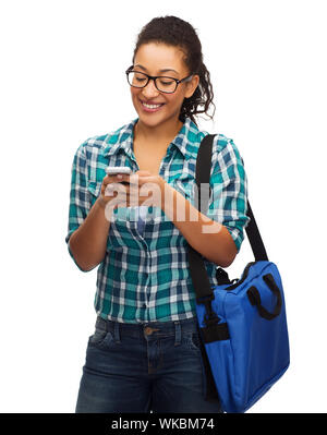 Bildung, Technologie und Personen Konzept - lächelnd weibliche afrikanische amerikanische Studenten in Brillen mit Smartphone und Tasche Stockfoto