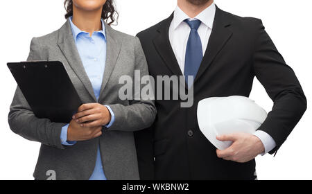 Wirtschaft, Architektur und Entwicklung Konzept - Geschäftsfrau und Geschäftsmann mit Zwischenablage und weißen Helm Stockfoto