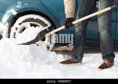 Transport, Winter und Fahrzeug-Konzept - Nahaufnahme des Menschen Graben im Schnee Auto stecken Stockfoto