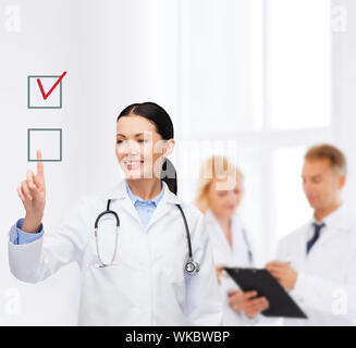lächelnd Ärztin zeigenden checkbox Stockfoto