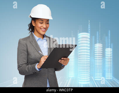 Geschäftsfrau in weißen Helm mit Zwischenablage Stockfoto