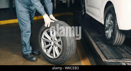 Mechatroniker Reifenwechsel in Auto KFZ-Werkstatt Stockfoto