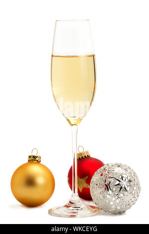 Glas Champagner mit goldenen, roten und Metall Weihnachtskugeln auf weißem Hintergrund Stockfoto