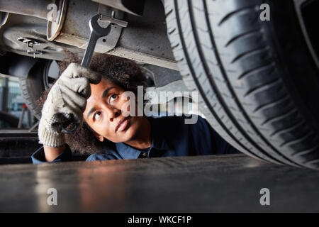 Afrikanische Frau als Mechatronik Auszubildende bei Inspektion oder Reparatur des Autos Stockfoto