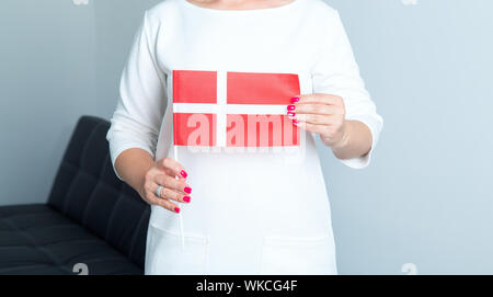 Nahaufnahme von einer Frau mit einem Flagge Dänemarks vor sich. Stockfoto
