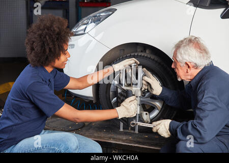 Automechaniker Team eine Spur auf dem Fahrgestell in der Werkstatt Stockfoto