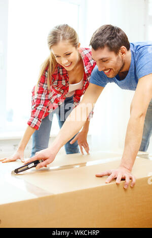 lächelnde paar Eröffnung großer Karton Stockfoto