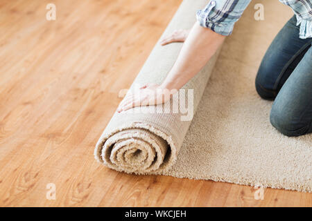 Reparatur, Aufbau und Konzept home - Nahaufnahme von männlichen Händen abrollen Teppich Stockfoto