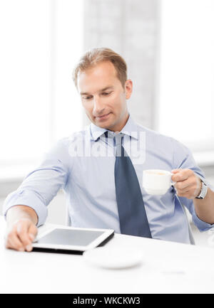 Geschäftsmann mit TabletPC und Kaffee im Büro Stockfoto