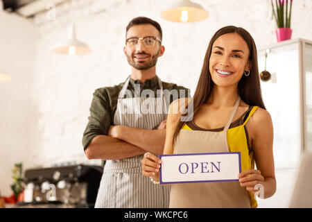Paar Gefühl aufgeregt. Junge gut aussehende Paar Gefühl aufgeregt vor Ihrer eigenen Coffee Shop öffnen Stockfoto
