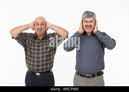 Zwei Männer mit Händen, die die Ohren bedecken Stockfoto