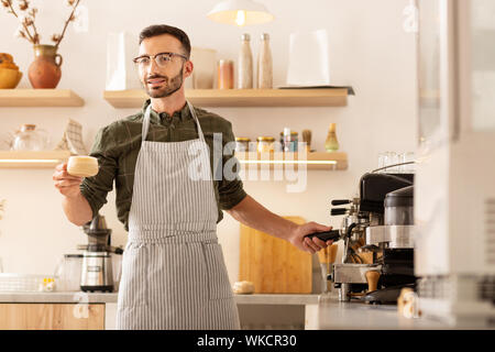 Geschäftsmann Kaffee machen. Unternehmer tragen gestreifte Schürze während Kaffee in seinem eigenen Cafeteria Stockfoto