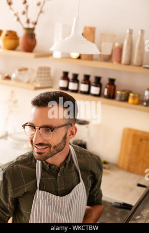 Barista lächelnd. Blick von oben auf die erfahrenen stattlichen barista Lächeln beim Gespräch mit dem Kunden Stockfoto