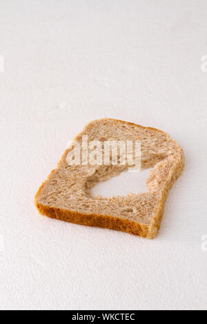 Eine Scheibe Brot mit ein Stück fehlt es auf einem weißen Hintergrund Bild mit Kopie Raum isoliert Stockfoto