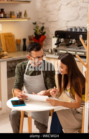 Erstellen von saisonalen Speisekarte. Mann lächelnd, während die Frau mit dem Erstellen der saisonalen Speisekarte für Ihr Cafe Stockfoto