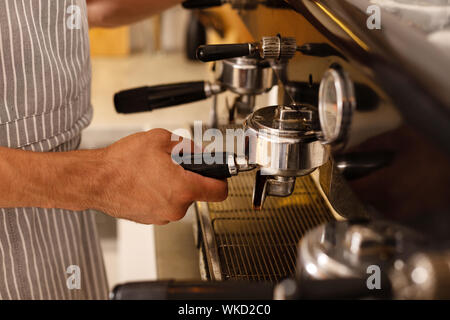 Barista. Nahaufnahme von Barista tragen gestreifte Schürze, Kaffee für Kunden am Morgen Stockfoto