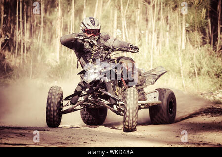 ATV Racer nimmt eine Wendung während eines Rennens auf einem staubigen Gelände. Stockfoto