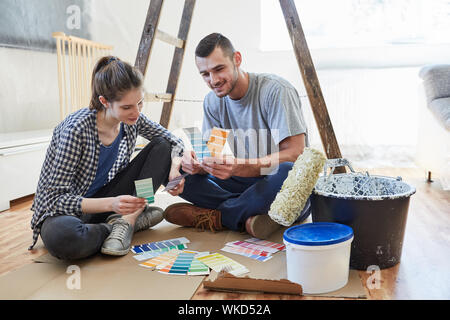 Junges Paar mit Farbmuster, die Wahl der richtigen Wandfarbe in der neuen Wohnung Stockfoto