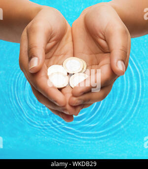 Womans schalenförmige Hände mit Euro-Münzen Stockfoto