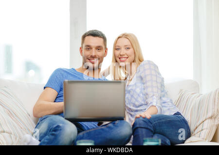 Liebe, Familie, Technologie, Internet und Glück Konzept - Lächeln glückliches Paar Witl Laptop-Computer zu Hause Stockfoto