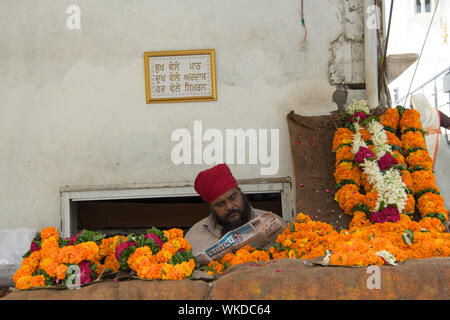 Mann, Verkauf von Blumen in Gurdwara, Gurdwara Bangla Sahib, New Delhi, Indien Stockfoto