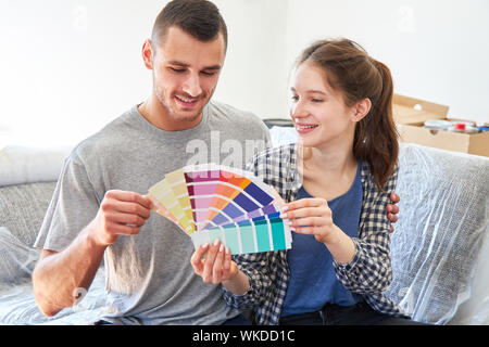 Junge Handwerker paar Farbmuster nimmt die rechte Wand Farbe für die Malerei Stockfoto