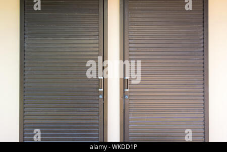 Metall Wellpappe Folie mit der Tür auf dem kleinen Lager an der Wand. Stockfoto