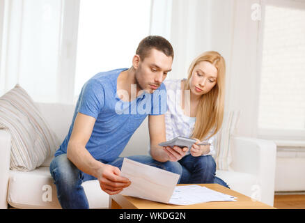 Steuern, Finanzen, Familie, Heimat und Glück Konzept - busy paar mit Papieren und Rechner zu Hause Stockfoto