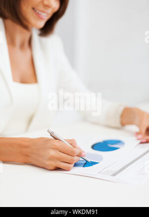 Geschäftsfrau, die Arbeit mit Grafiken im Büro Stockfoto