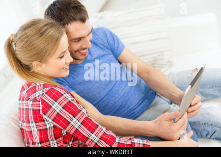 Liebe, Familie, Technik, Internet und Glück Konzept - lächelnd glückliches Paar mit Tablet PC-Computer zu Hause. Stockfoto